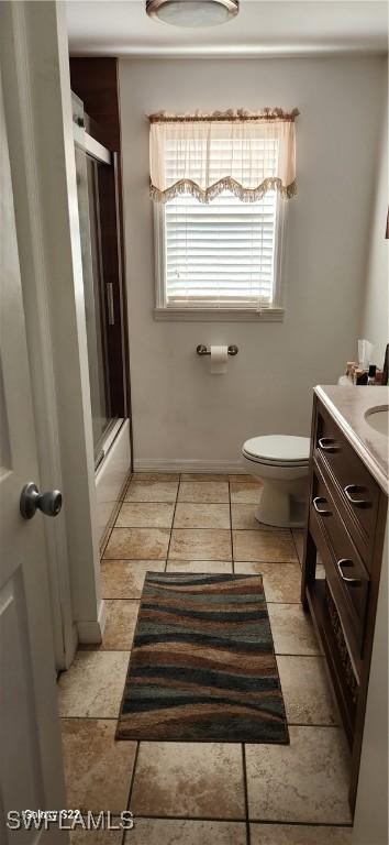 full bathroom with a shower with door, vanity, and toilet