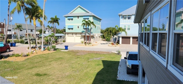 view of yard with a garage, driveway, and a residential view