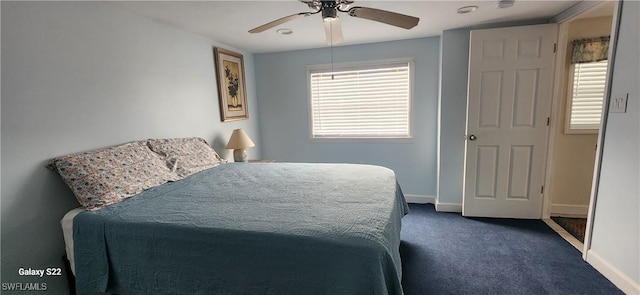 bedroom with ceiling fan and dark colored carpet