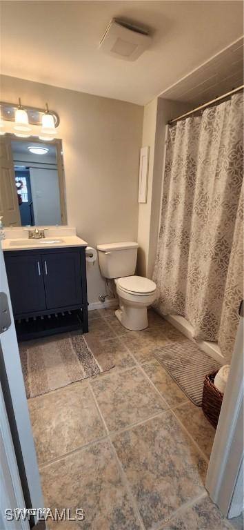 full bath with a shower with shower curtain, vanity, and toilet