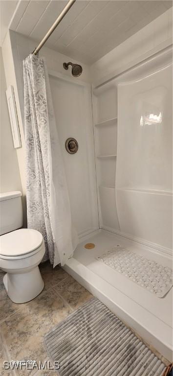 bathroom featuring a stall shower and toilet