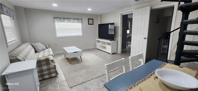 living area featuring stairs, baseboards, and recessed lighting