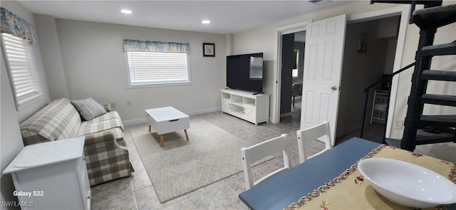 living area with recessed lighting, baseboards, and stairs