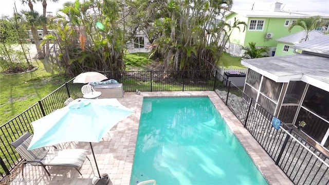 view of swimming pool with a fenced in pool, a yard, a fenced backyard, and a sunroom