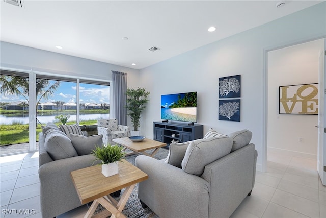 living room featuring a water view and light tile patterned floors