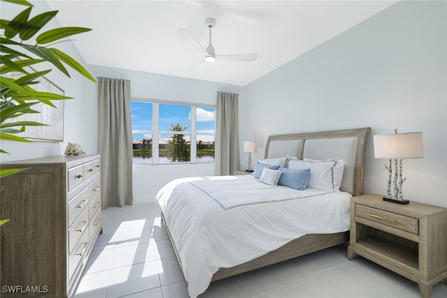 bedroom featuring ceiling fan, light tile patterned floors, a water view, and vaulted ceiling