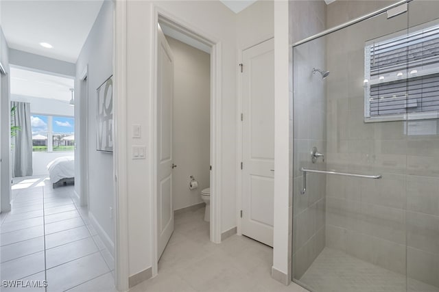 bathroom with tile patterned floors, toilet, and an enclosed shower