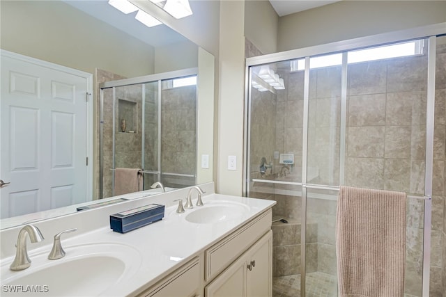 bathroom with vanity, a healthy amount of sunlight, and a shower with door