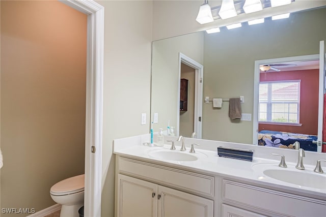 bathroom featuring toilet, ceiling fan, and vanity