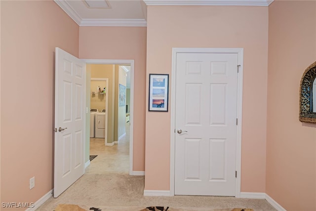 hall with light carpet, crown molding, and washing machine and dryer