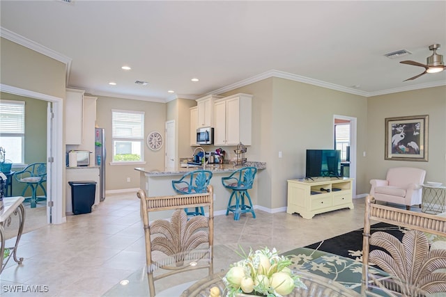 living room featuring light tile patterned floors, ornamental molding, and ceiling fan