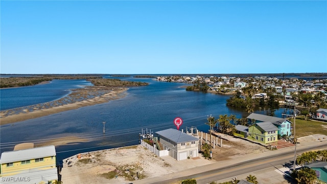 drone / aerial view featuring a water view and a view of the beach