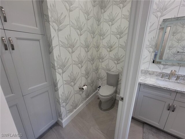 bathroom featuring tile patterned flooring, vanity, and toilet