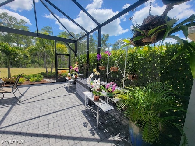 view of patio featuring glass enclosure