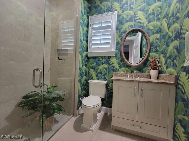 bathroom with vanity, tile patterned flooring, a shower with shower door, and toilet