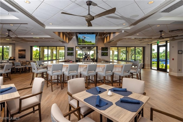 dining space with light wood-type flooring, ceiling fan, and a healthy amount of sunlight