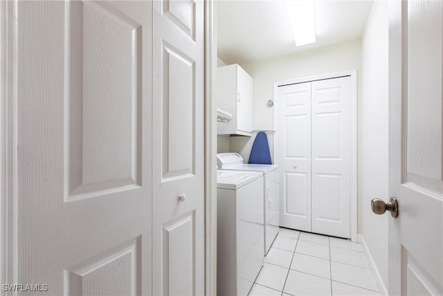 washroom featuring light tile patterned floors, cabinets, and washer and dryer