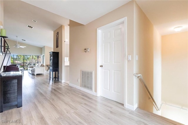 hall with vaulted ceiling and light hardwood / wood-style floors