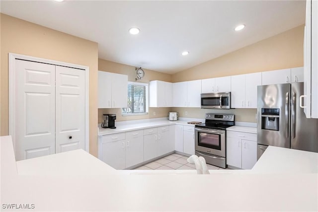 kitchen featuring light countertops, vaulted ceiling, recessed lighting, white cabinets, and stainless steel appliances