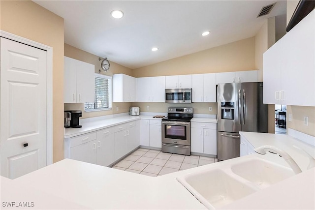 kitchen featuring a sink, stainless steel appliances, light tile patterned floors, and white cabinetry