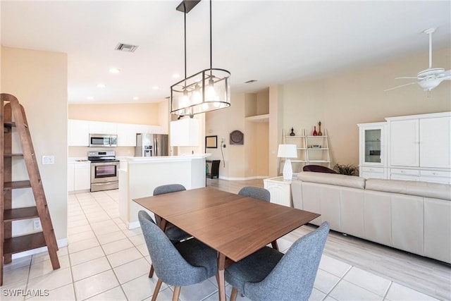 dining space featuring visible vents, lofted ceiling, light tile patterned floors, recessed lighting, and a ceiling fan