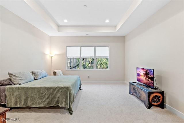 bedroom featuring light colored carpet and a tray ceiling