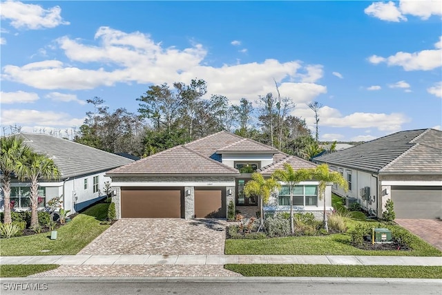 12047 Oleander Ave, Naples, FL 34120 - ranch-style home with a garage, decorative driveway, a front lawn, and a tile roof
