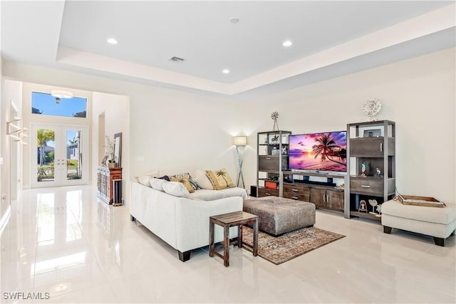 living room featuring french doors and a raised ceiling