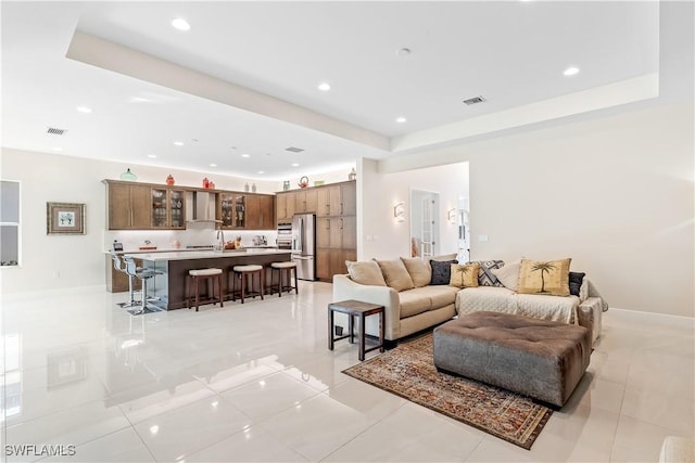 tiled living room featuring a tray ceiling