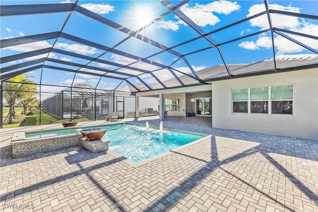 view of swimming pool with glass enclosure, a pool with connected hot tub, and a patio area