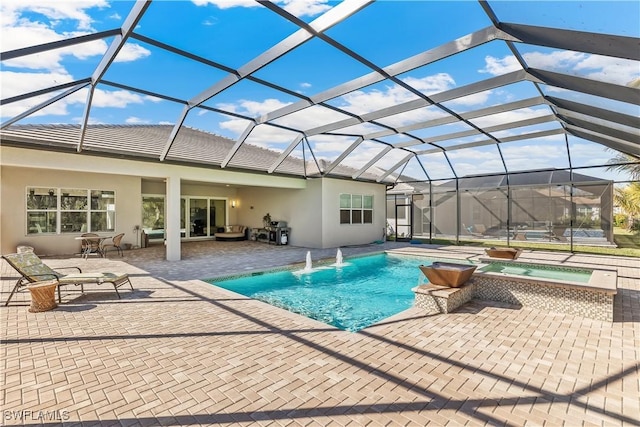 view of swimming pool with an in ground hot tub, area for grilling, a patio area, and glass enclosure