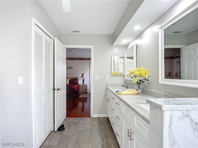 full bath featuring double vanity, a closet, visible vents, a sink, and baseboards