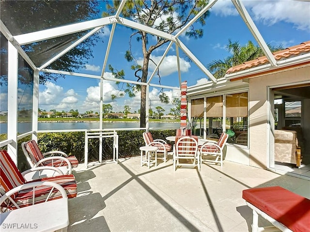 sunroom featuring a water view