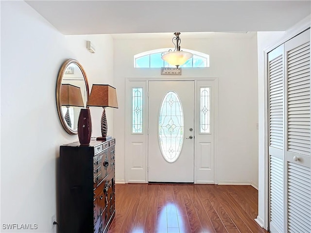 entryway with dark wood finished floors and baseboards