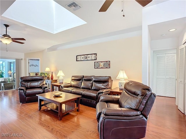 living area with ceiling fan, visible vents, and wood finished floors