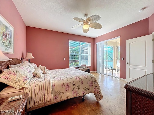 bedroom with ceiling fan, access to outside, and a textured ceiling