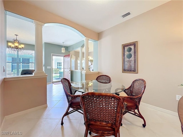 dining space featuring light tile patterned floors and ornate columns