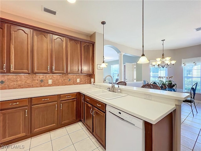 kitchen with kitchen peninsula, a wealth of natural light, decorative light fixtures, and dishwasher