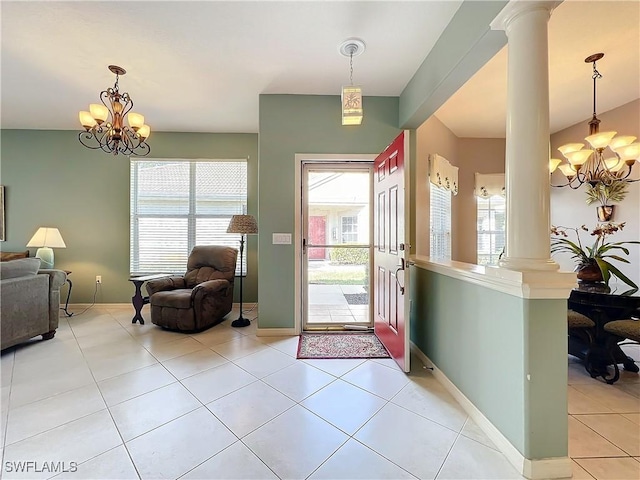 foyer featuring light tile patterned floors, decorative columns, a wealth of natural light, and a notable chandelier