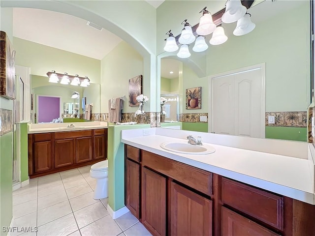 bathroom featuring tile patterned floors, toilet, vanity, and walk in shower