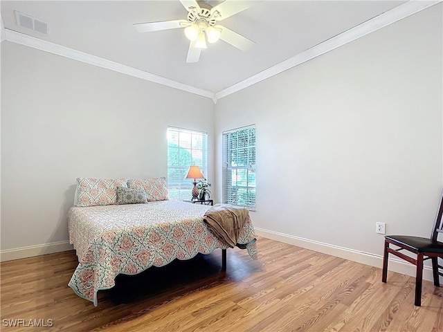 bedroom with hardwood / wood-style flooring, ceiling fan, and crown molding