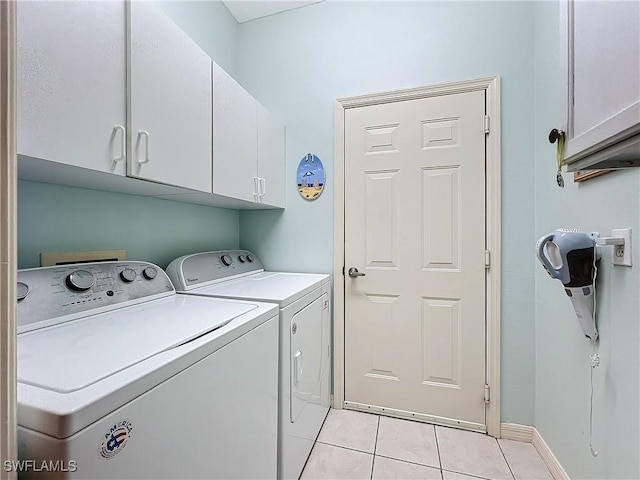 laundry room featuring cabinets, light tile patterned floors, and independent washer and dryer