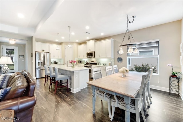 dining space featuring a healthy amount of sunlight, dark hardwood / wood-style floors, and sink