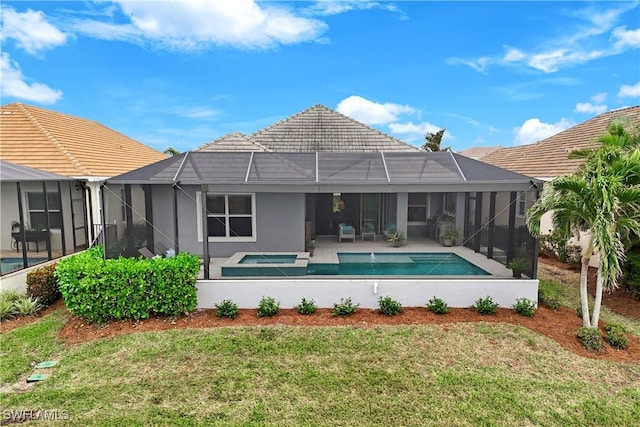 rear view of property featuring a swimming pool with hot tub, a lanai, a lawn, and a patio