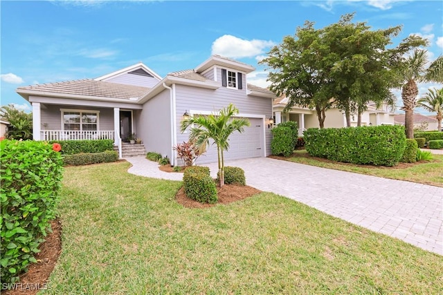 view of front of property featuring a garage, a front yard, and covered porch