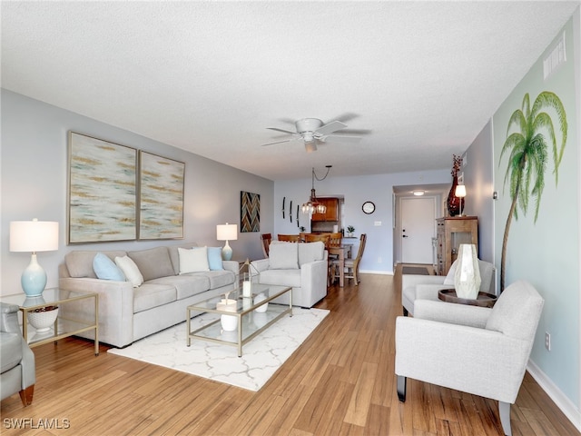 living room with ceiling fan, hardwood / wood-style floors, and a textured ceiling