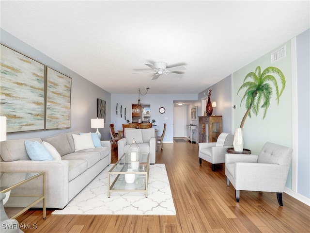 living room featuring light wood-type flooring and ceiling fan