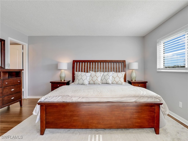 bedroom with a textured ceiling and hardwood / wood-style floors