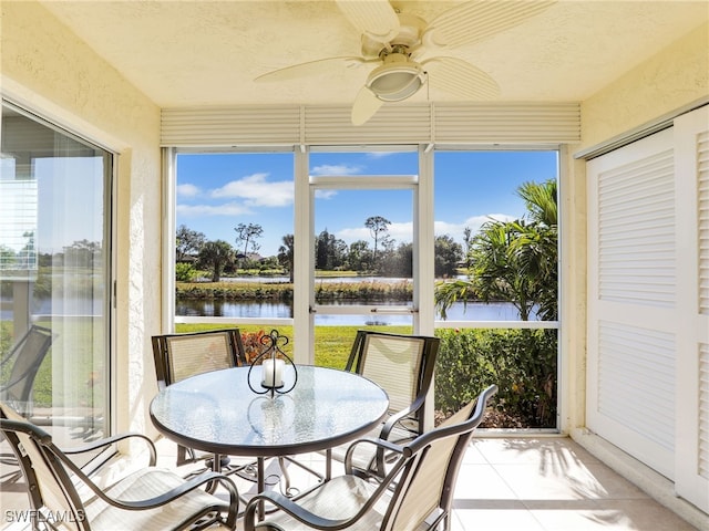 sunroom with a water view and ceiling fan