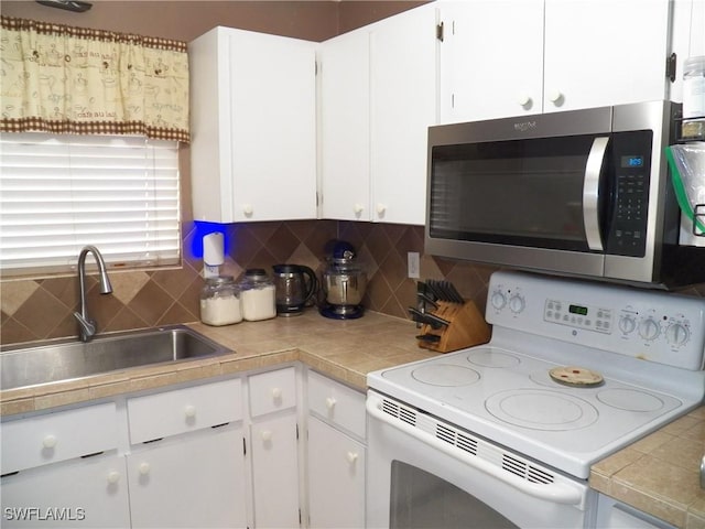 kitchen with white electric range, backsplash, white cabinetry, and sink